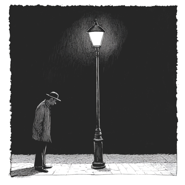 A man looking into the lit area of a street.